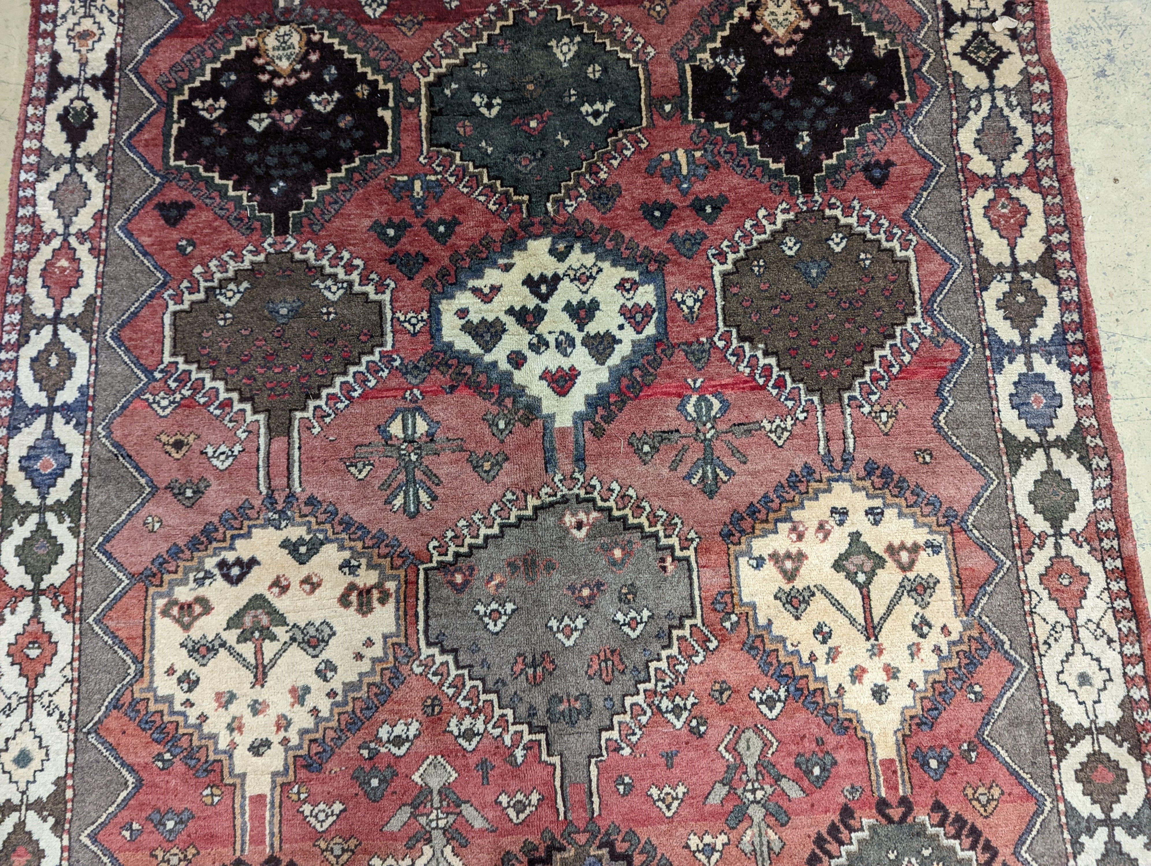 A Persian Shiraz red ground rug, 280 x 150cm